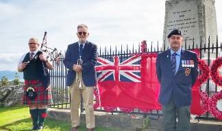 Image:At the war memorial near Tarbert on Loch Fyne, Argyll, Scotland. L-R: John Hunt (piper), Kevin MacKaveney (who performed the Reveille), and Aggie Dennis who related the history of and sacrifices by the Merchant Navy and who read the Kohima Epitaph. Image: Kevin MacKaveney
